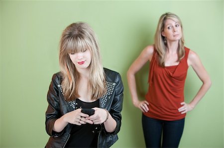 Concerned mom watches teen send text messages on phone Stock Photo - Budget Royalty-Free & Subscription, Code: 400-05754653