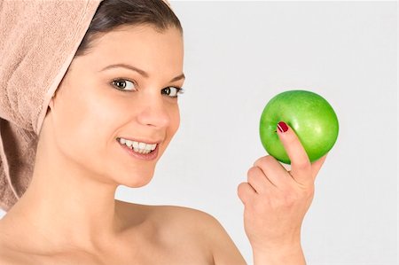 Beautiful young woman after bath with a towel on her head and an apple in her hand. Over white. Not isolated. Stock Photo - Budget Royalty-Free & Subscription, Code: 400-05755495