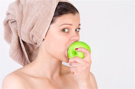 Beautiful young woman after bath with a towel on her head and an apple in her hand. Over white. Not isolated. Stock Photo - Budget Royalty-Free & Subscription, Code: 400-05755496