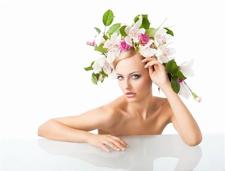 eggs with face - young sexy beautiful woman with naked shoulder and wearing a big crown of flower and leaves as spring queen, she is behind the table,  her face is turned of three quarters, she looks in to the lens with an actractive expression. Her right arm is on the table, her left arm is bent and her left hand is near the face. Stock Photo - Budget Royalty-Free & Subscription, Code: 400-05755511