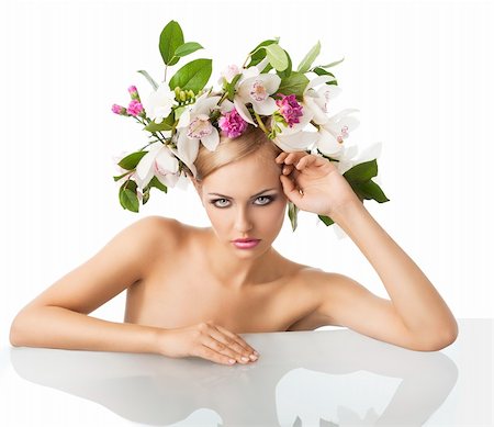 eggs with face - young sexy beautiful woman with naked shoulder and wearing a big crown of flower and leaves as spring queen, she is behind the table in front of the camera, looks in to the lens with an actractive expression. Her right arm is on the table, her left arm is bent and her left hand is near the face. Stock Photo - Budget Royalty-Free & Subscription, Code: 400-05755512