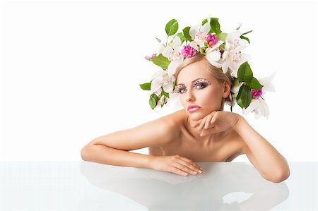 eggs with face - young sexy beautiful woman with naked shoulder and wearing a big crown of flower and leaves as spring queen, she is behind the table, looks in to the lens with an actractive expression. Her right arm is on the table, and her chin is resting on right hand. Stock Photo - Budget Royalty-Free & Subscription, Code: 400-05755513