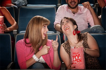 simsearch:400-06138368,k - Two pretty young women in the audience laugh together Stock Photo - Budget Royalty-Free & Subscription, Code: 400-05755789