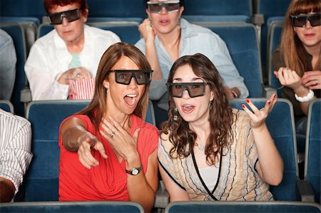 simsearch:400-06138368,k - Surprised woman with friend in 3D glasses points index finger Fotografie stock - Microstock e Abbonamento, Codice: 400-05755791