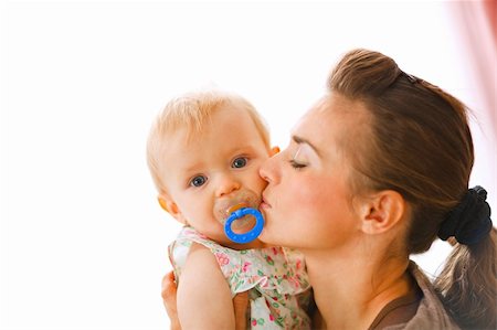 simsearch:400-05899075,k - Young mother kissing baby with soother Fotografie stock - Microstock e Abbonamento, Codice: 400-05750408