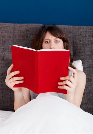 Beautiful young woman reading a book with a astonish expression Stock Photo - Budget Royalty-Free & Subscription, Code: 400-05750440