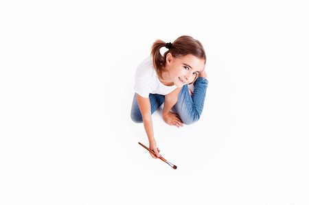 Top view of a happy girl sitting on floor holding a paint-brush Stock Photo - Budget Royalty-Free & Subscription, Code: 400-05750487