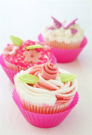 simsearch:400-04615795,k - Vanilla cupcakes with buttercream icing and various decorations on white background Stockbilder - Microstock & Abonnement, Bildnummer: 400-05750550