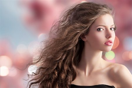 simsearch:400-05744994,k - beauty fashion portrait of a very young cute brunette with long curly hair with hairstyle flying in the wind on cherry blossom bokeh background Stock Photo - Budget Royalty-Free & Subscription, Code: 400-05750577