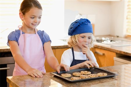 simsearch:400-05749772,k - Siblings stealing cookies off the kitchen counter Stock Photo - Budget Royalty-Free & Subscription, Code: 400-05751236