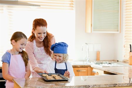 simsearch:400-05749768,k - Smiling mother presenting finished cookies to her children Stock Photo - Budget Royalty-Free & Subscription, Code: 400-05751232