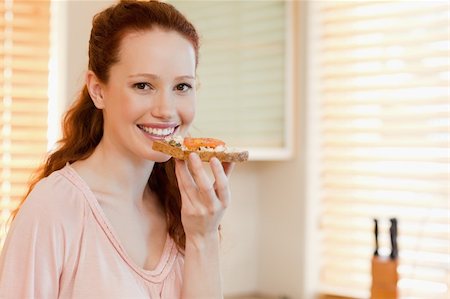 eating bread and butter - Smiling woman with slice of bread in her hand Stock Photo - Budget Royalty-Free & Subscription, Code: 400-05751254