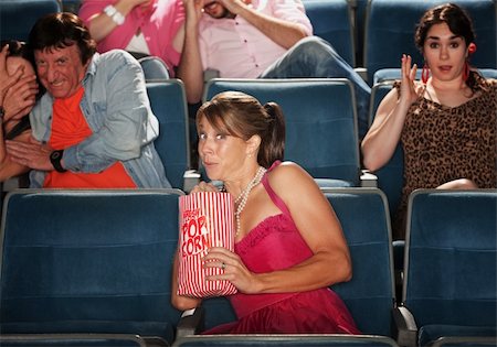 simsearch:400-06138368,k - Woman snacks on popcorn with group seated in theater Fotografie stock - Microstock e Abbonamento, Codice: 400-05751359