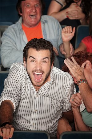 simsearch:400-06138368,k - Young Caucasian laughs out loud in theater Fotografie stock - Microstock e Abbonamento, Codice: 400-05751362