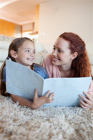 simsearch:400-05751566,k - Mother and daughter on the floor looking at magazine together Stock Photo - Budget Royalty-Free & Subscription, Code: 400-05751549