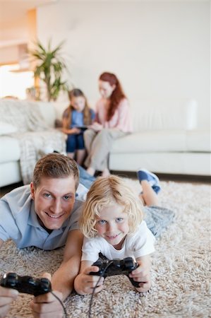simsearch:400-05297936,k - Father and son enjoying video games together in the living room Stock Photo - Budget Royalty-Free & Subscription, Code: 400-05751540