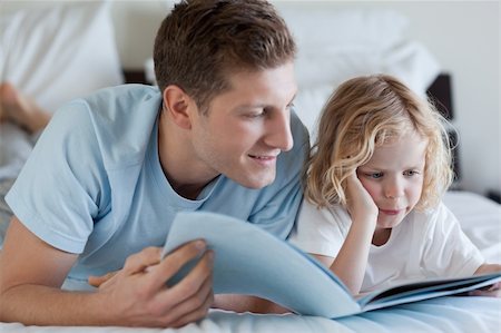 simsearch:400-05751566,k - Father and son reading a magazine together Stock Photo - Budget Royalty-Free & Subscription, Code: 400-05751565