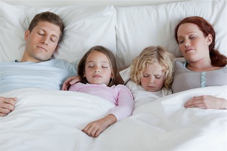 Adorable young family sleeping in the bed together Stock Photo - Budget Royalty-Free & Subscription, Code: 400-05751576