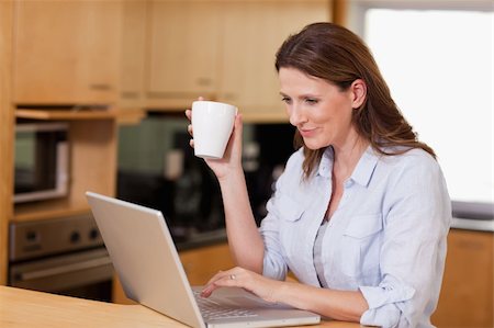 simsearch:400-05741872,k - Woman drinking tea while on her laptop Foto de stock - Super Valor sin royalties y Suscripción, Código: 400-05751632