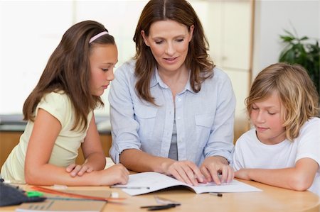 simsearch:400-05751679,k - Woman helping her children with homework Stock Photo - Budget Royalty-Free & Subscription, Code: 400-05751672