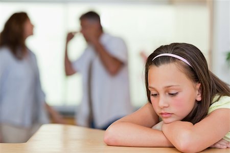 divorced family - Sad looking girl with her fighting parents behind her Stock Photo - Budget Royalty-Free & Subscription, Code: 400-05751692