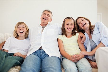 Laughing family sitting on the sofa together Stock Photo - Budget Royalty-Free & Subscription, Code: 400-05751867