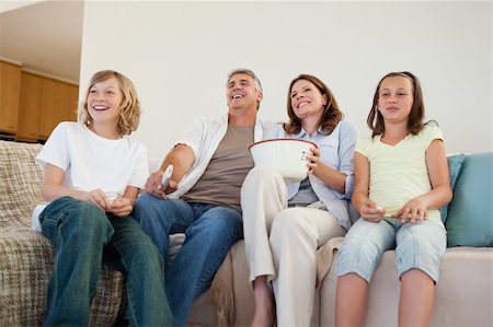 Family on the couch watching tv together Stock Photo - Budget Royalty-Free & Subscription, Code: 400-05751863