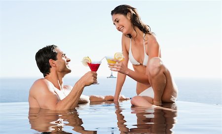 Happy couple having cocktails in the pool Stock Photo - Budget Royalty-Free & Subscription, Code: 400-05751940