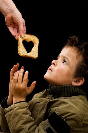 poor child need help - Feeding the poor concept with dirty kid receiving slice of bread - on black Stock Photo - Budget Royalty-Free & Subscription, Code: 400-05752349