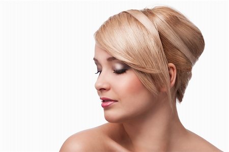 simsearch:400-06089201,k - close up beauty portrait of a young and cute blond girl with hair style over white. she's almost turned in profile, looks down and slightly smiles. Stockbilder - Microstock & Abonnement, Bildnummer: 400-05752509