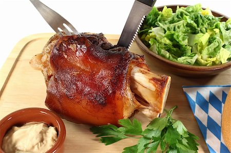 schlank - Pork hock with mustard, lettuce and parsley on a board with cutlery Stock Photo - Budget Royalty-Free & Subscription, Code: 400-05752701