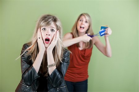 Mom threatens to cut daughter's credit cards with a scissors Stock Photo - Budget Royalty-Free & Subscription, Code: 400-05753503