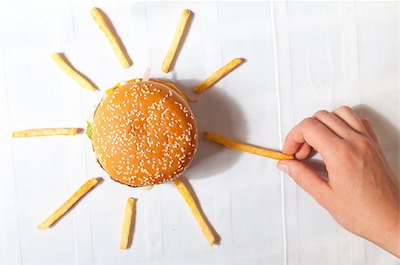 Hand is taking potato from sun made of hamburger and french fries Stock Photo - Budget Royalty-Free & Subscription, Code: 400-05875448