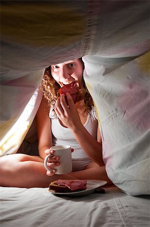 woman is sitting under cover in bed and eating Stock Photo - Budget Royalty-Free & Subscription, Code: 400-05875454