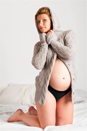 simsearch:400-04859723,k - fashionable pregnant woman wearing woolen cardigan is looking at camera Fotografie stock - Microstock e Abbonamento, Codice: 400-05875629
