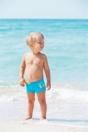 Cute little boy stands in front of the blue sea Stock Photo - Budget Royalty-Free & Subscription, Code: 400-05876136