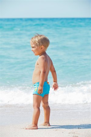 Cute little boy stands in front of the blue sea Stock Photo - Budget Royalty-Free & Subscription, Code: 400-05876130