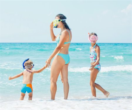 Happy young mother with her child with snorkeling equipment on sandy tropical beach Stock Photo - Budget Royalty-Free & Subscription, Code: 400-05877578