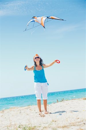 Young cute woman playing with a colorful kite on the tropical beach. Vertikal veiw Stock Photo - Budget Royalty-Free & Subscription, Code: 400-05877875