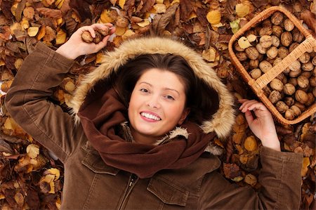 people with forest background - A portrait of a pretty young woman smiling lying on leaves with a basket full of walnuts Stock Photo - Budget Royalty-Free & Subscription, Code: 400-05878838