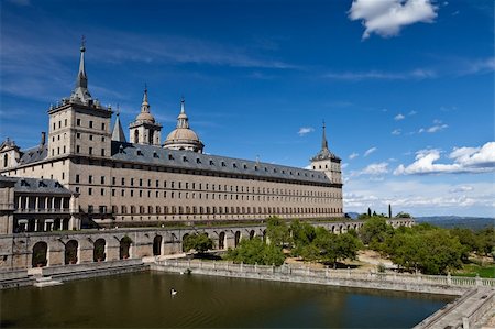 San Lorenzo de El Escorial Monastery with a reflecting pool with floating swan. The towers of the church and monastery are set of by a bright blue sky with a few white clouds. Stock Photo - Budget Royalty-Free & Subscription, Code: 400-05879681