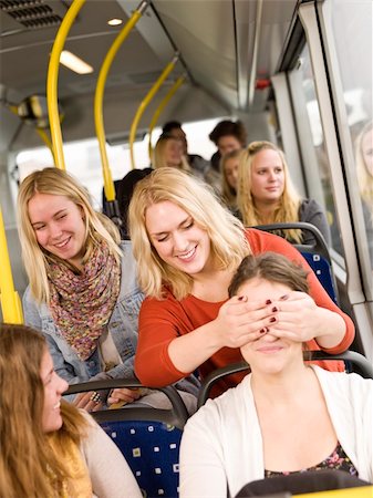 Young women playing peek-a-boo on the bus Stock Photo - Budget Royalty-Free & Subscription, Code: 400-05884031