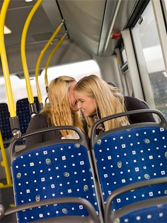 Two young women wispering secrets on the busn Stock Photo - Budget Royalty-Free & Subscription, Code: 400-05884144