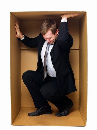 simsearch:640-08089827,k - Well dressed businessman in a tight cardboard box isolated on white background Photographie de stock - Aubaine LD & Abonnement, Code: 400-05884268