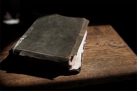Leather covered old bible lying on a wooden table in a beam of sunlight Shallow Depth of field â?? Focus on Text â??Holy Bibleâ? Stock Photo - Budget Royalty-Free & Subscription, Code: 400-05885460
