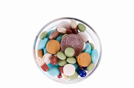 Fifty cents in glass saucer full of different pills on white background Stock Photo - Budget Royalty-Free & Subscription, Code: 400-05886023