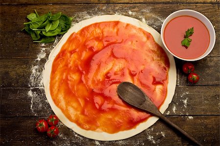 pizza dough with tomato sauce on rustical wooden table Stockbilder - Microstock & Abonnement, Bildnummer: 400-05888065