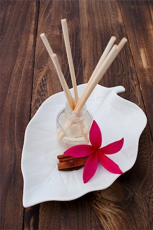 simsearch:400-04427380,k - Red Tropical Plumeria Frangipani with Aromatherapy Oil and Cinnamon Stick on wooden table for spa and wellness concept Photographie de stock - Aubaine LD & Abonnement, Code: 400-05888862