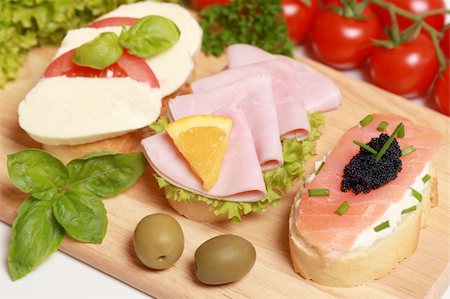 Fingerfood topped with ham, smoked salmon and caviar, tomatos and mozzarella cheese Stock Photo - Budget Royalty-Free & Subscription, Code: 400-05888942