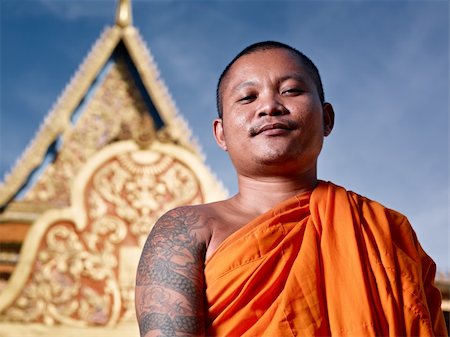 Mid adult Asian monk smiling at camera in buddhist monastery, Phnom Penh, Cambodia, Asia. Low angle Stock Photo - Budget Royalty-Free & Subscription, Code: 400-05889234